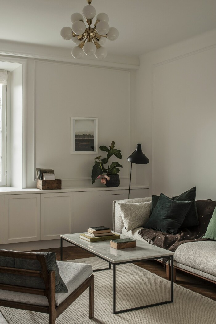 Soffa och bord från Bolia. Stolen är ett auktionsfynd med omklädd dyna. Taklampa från Domino antik. Golvlampa, Schottlander. Platsbyggd bänk med inbyggd tv-hiss. Foto på väggen av Kalle Gustafsson. vardagsrum hemma hos modefotografen Sara Bille