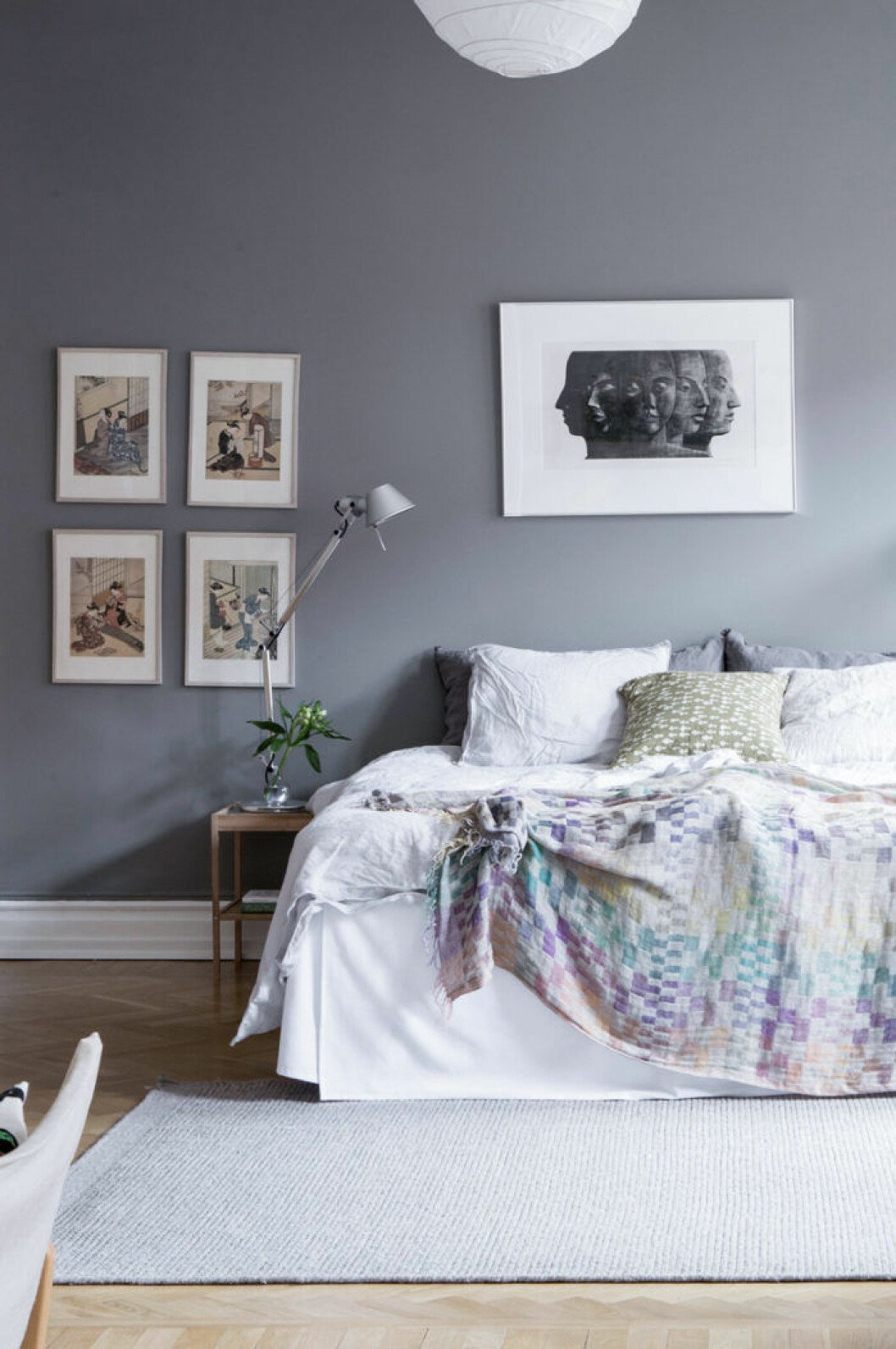 Scandinavian decoration and ideas. Bedroom with grey painted walls and art. Cozy bedding.