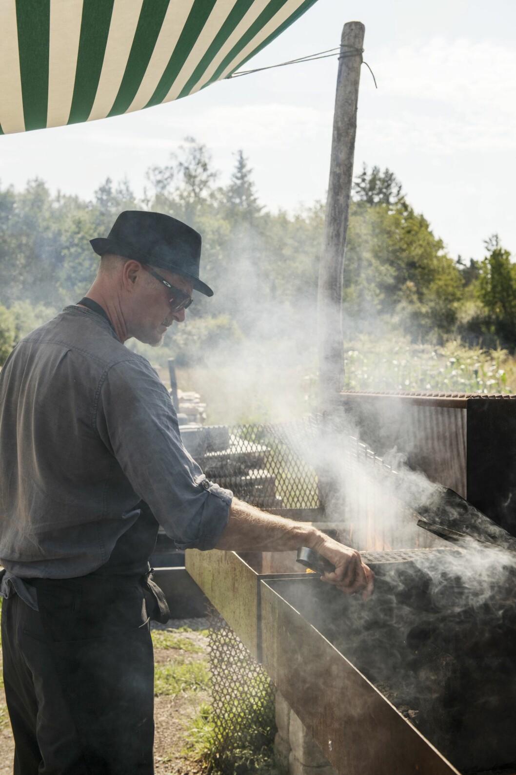 Johnny vid den stora grillstationen. Här är det kockgästspel, långluncher och Farmers Market under juli-september. Johnny vid den stora grillstationen
