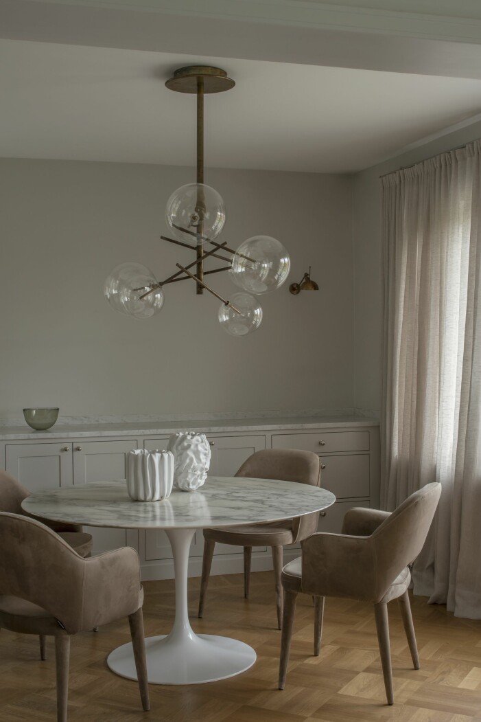 Matplatsen i köket. Vägglampa, Lightworks, taklampa i handblåst glas och mässing, Galotti & Radice, båda Garbo Interiör, matbordet Tulip av Eero Saarinen, stolar, Artilleriet, krukor, Tufva design, gardiner, Astrid. Matplats köket