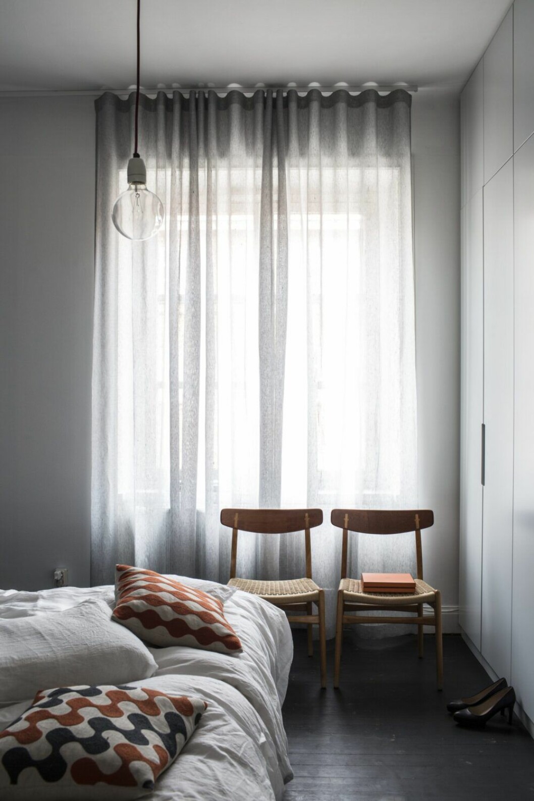 Sovrum mot gården med stort träd. Stolar CH 23 Spisestolen av Hans J Wegner, Carl Hansen & søn. Kuddar av Charlene Mullen, en annan Londonvän som jobbade i den gamla magasinsbyggnaden. sovrum
