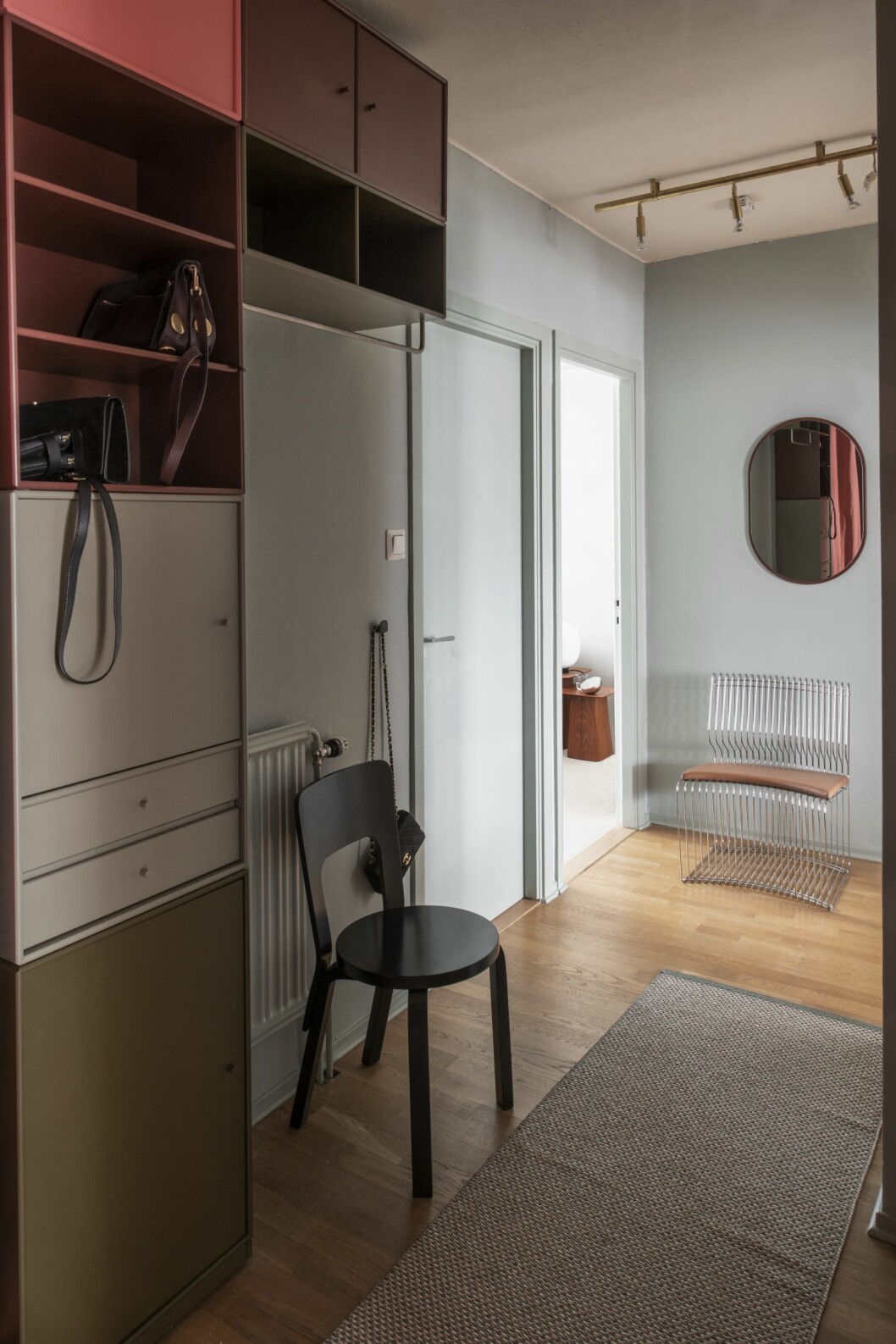 Stolikoner av Aalto och Verner Panton från Artek respektive Montana. Väggknopp av Monica Förster och dörrhandtag av Thomas Sandell, båda från Habo Selection. Matta från Pappelina. Hall med kontrasterande kulörer, modulsystem från Montana och stolikoner av Aalto och Verner Panton från Artek.