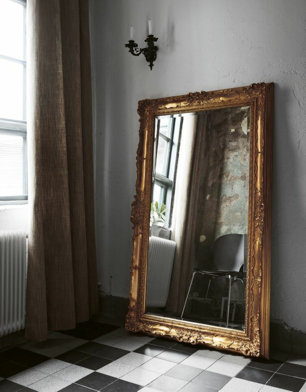 The grand entrance has original floors and walls from the slaughterhouse days. The huge mirror and candleholders are French antique finds. 124559_residence_annica_eklund_010lev
