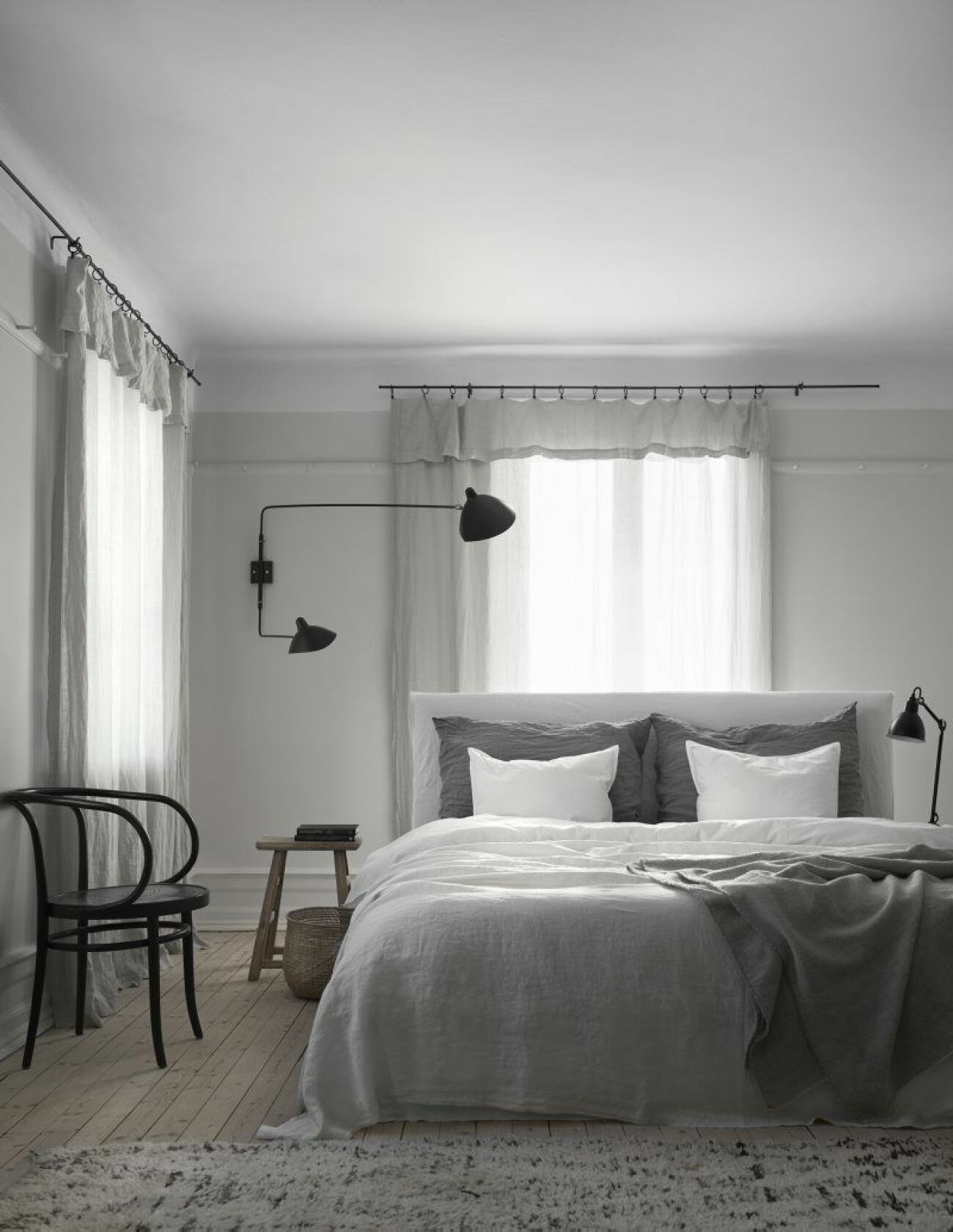 Sängen är bäddad med sängkläder i bomull och linne från Society. Matta från Artilleriet. Vägglampa Serge Mouille.