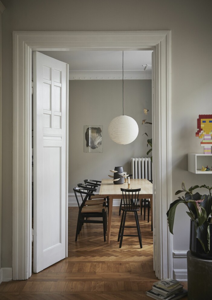 Stort matbord i massiv ask med lådor och infällda ljusstakar i design av Sekt. Mobil skulptur, design Lovisa Hansson och Johanna Nilsson, säljs bland annat på Artilleriet. Keramik av Milan Kosovic.