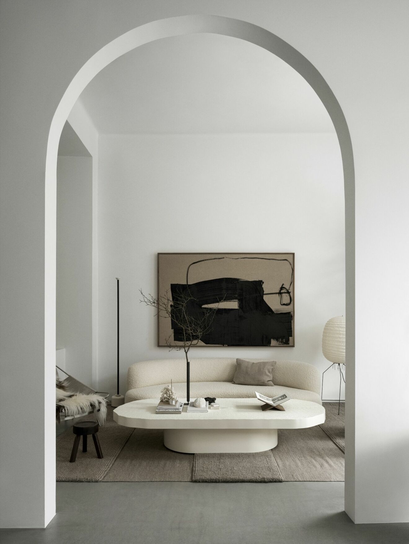 Vitt rum valv abstrakt konst välvd soffa golvlampa personligt stilleben soffbord mjuka former