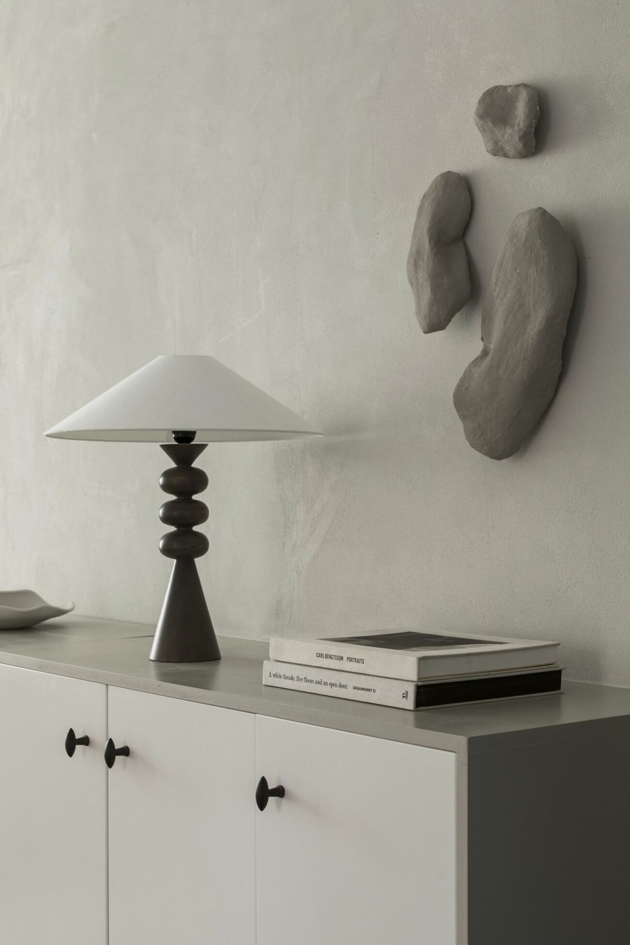 Lampa från Zara home med skärm från Watt &amp; veke, väggskulpturer av Lovisa Häger.