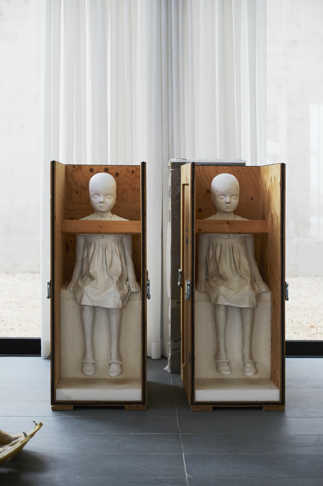 Charlottes skulpturer Den minsta av oss från 2009 står i ateljén på Ibiza i sina reselådor.