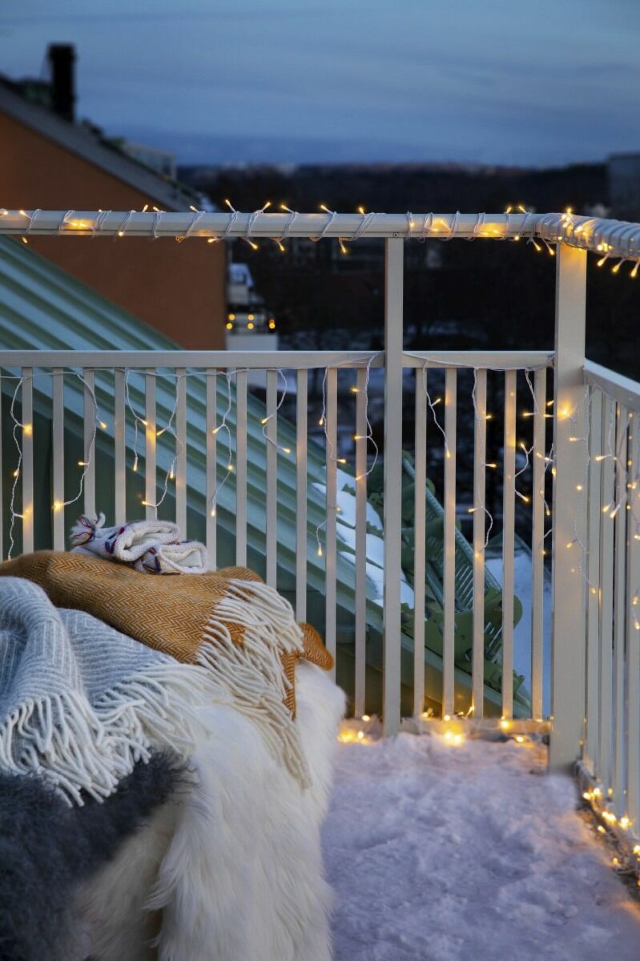 juldekorerad balkong med ljusslinga runt räcket