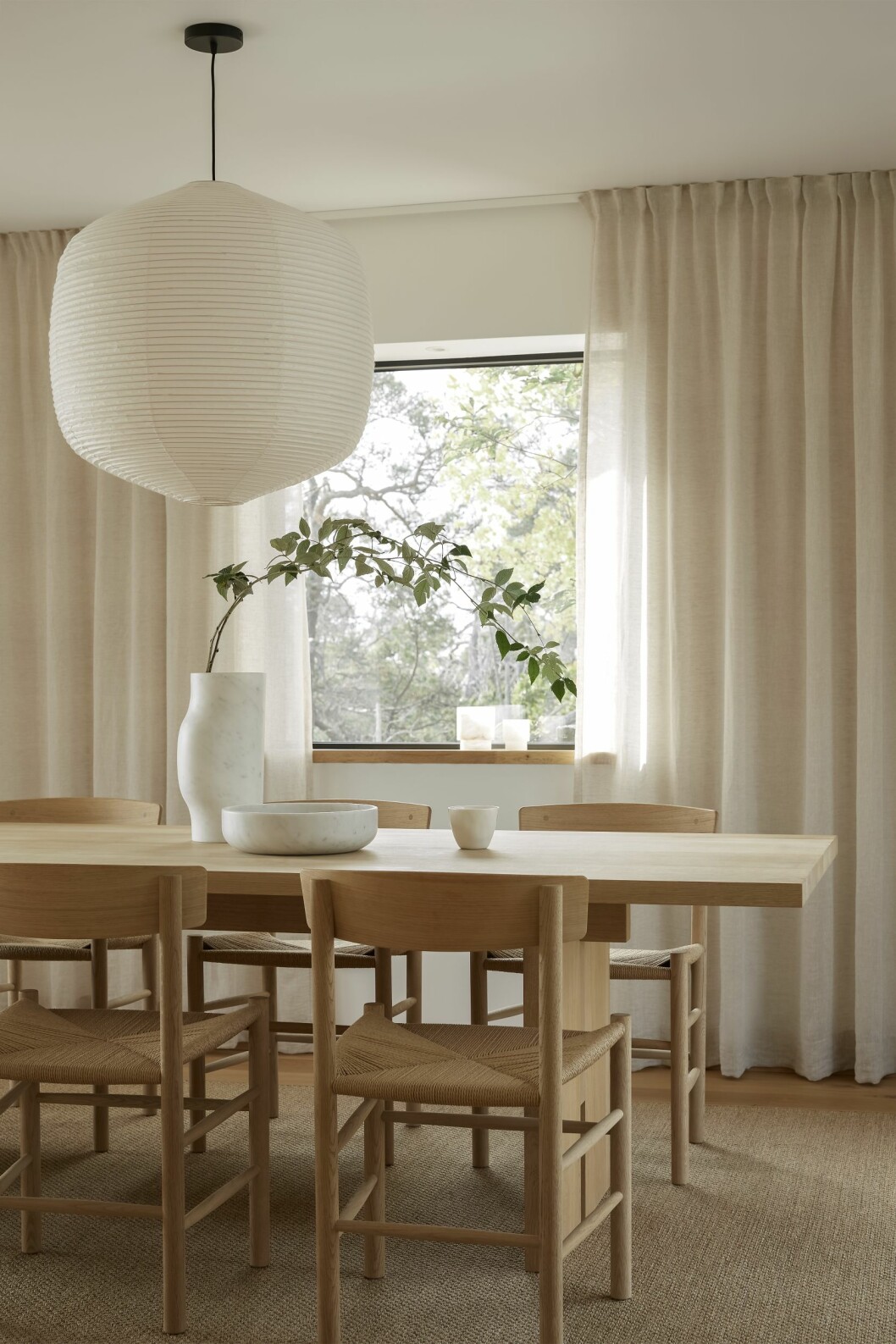 Matplats med vidunderlig utsikt. Antwerp dining table från Noorstad. Stolar J39 i såpad ek, Fredericia. Sisalmatta, Kjellbergs/Målarboden. Linnegardiner, Gotain, Marmorvas, Collection particulière och skål av Vincent Van Duysen från When objects work/Bert van Hoecke Interiors. Taklampa Hotaru marker light, design Barber & Osgerby för Oseki & co/Bautier.com. Hus på Dalarö stylat av Pella Hedeby.