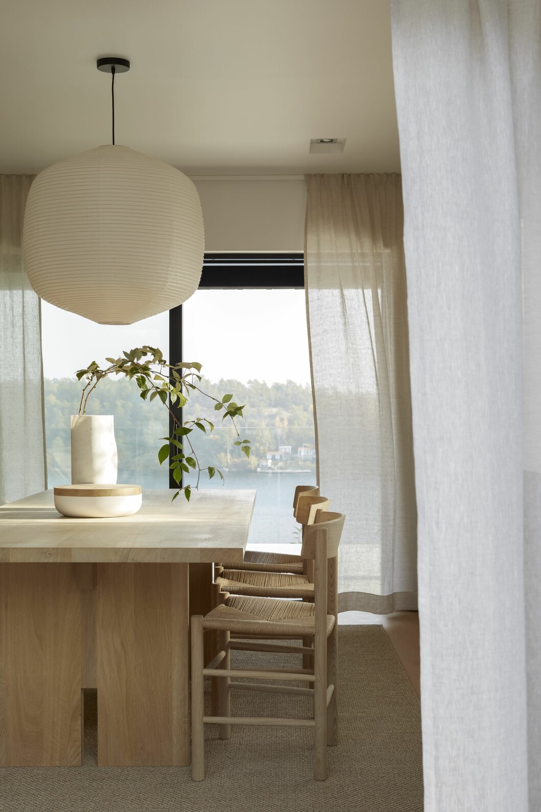 Antwerp dining table från Noorstad. Stolar J39 i såpad ek, Fredericia. Sisalmatta, Kjellbergs/Målarboden. Linnegardiner, Gotain. Marmorvas, Collection particulière och skål av Vincent Van Duysen från When objects Work/Bert van Hoecke interiors. Taklampa Hotaru marker light, design Barber & Osgerby för Oseki & co/Bautier.com. Hus på Dalarö stylat av Pella Hedeby.