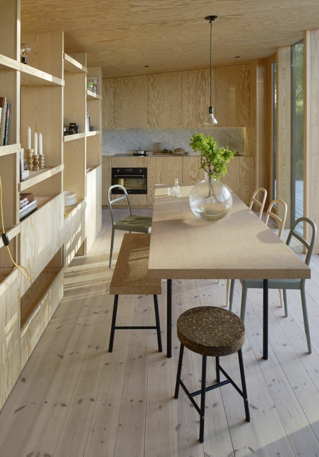 Kök och bokhylla är liksom resten av husets insida klädda i kvistfri furuplywood. Bord, bänk och pall Ilse Crawford för Ikea, Stolarna av Inga Sempé för Gärsnäs. Vas Pallo av Carina Seth Andersson. Sommarhus Andreas Martin-Löf