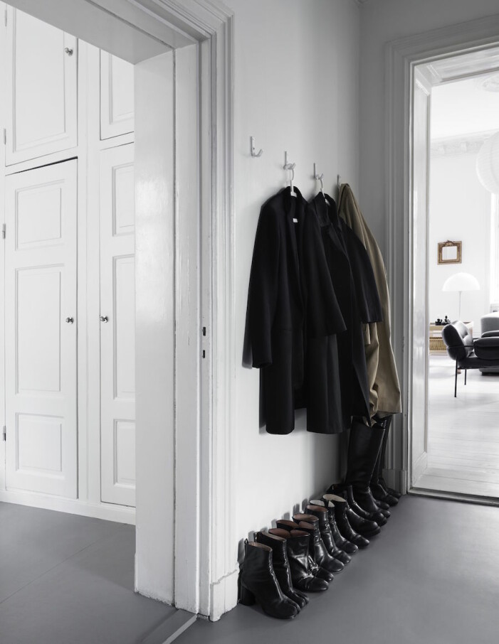<em>I hallen en diger samling av svarta stövletter. </em> Bild på jackor och skor hemma hos Anna Teurnell.