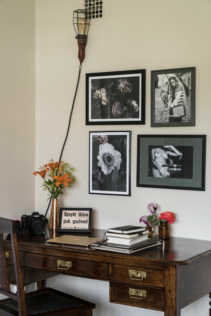 I vardagsrummet finns en arbetshörna med skrivbord och stol som båda är vintagefynd. Tavlorna är en mix av print från Love Warriors, tidningsurklipp och en bild från en resa till Kuba. Citatet på skrivbordet är ett kul minne från när Erika jobbade som kock på en isbrytare i Svalbard, M/S Stockholm. Arbetsplats med bilder.