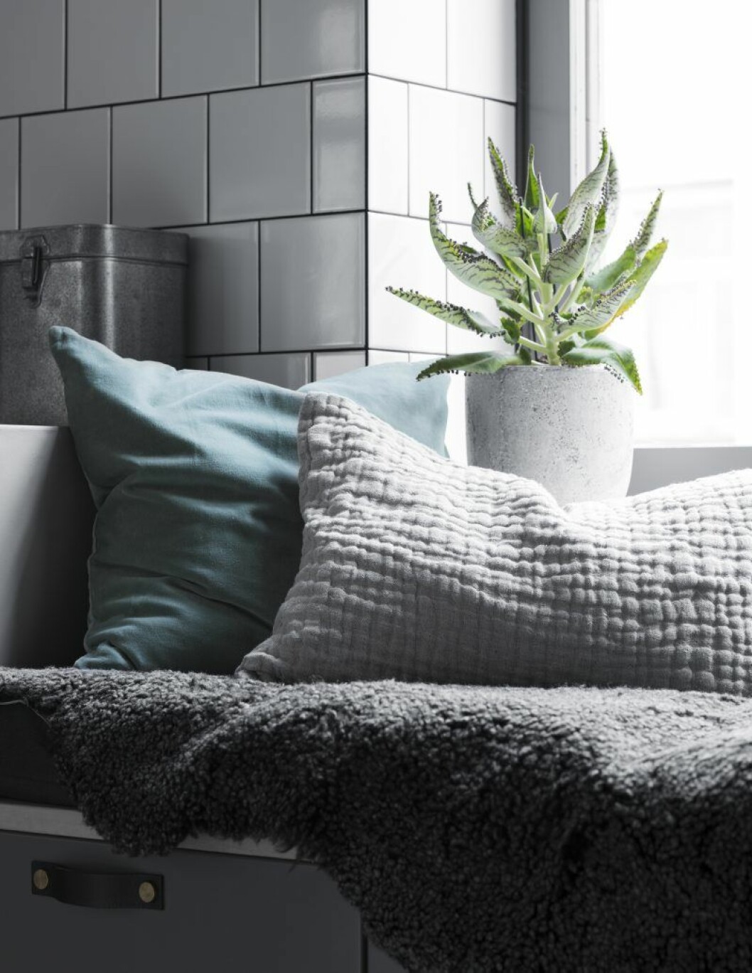 Köksluckorna kommer från Ikea och fårskinnsfällarna från parets sommarställe på Gotland. Sittkudde Åhléns. Den blå kudden är från Ceannis, den grå från Himla. arkitektparets lagenhet foto kristofer johnsson2