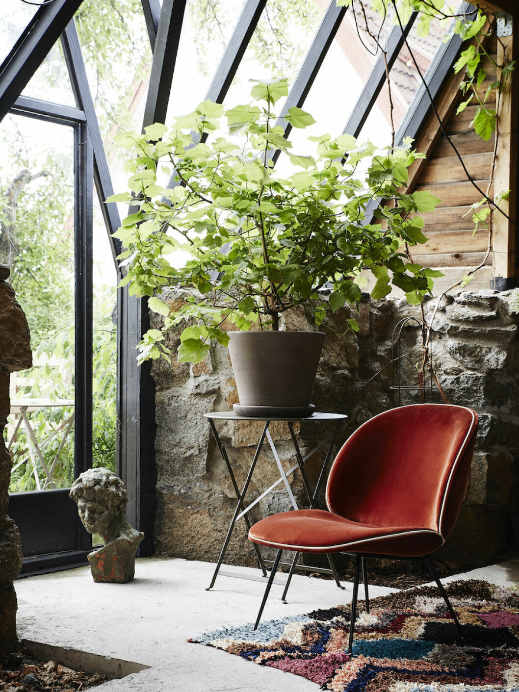 Bord Bistro folding table från Fermob, 1 460:-, kruka från Bergs potter, 1 099:-, stol Beetle lounge chair från Gubi, 14 695:-, vintagematta Boucharouette, från 3 195:-. Bord, kruka och sammetsstol inuti Artilleriets magiska orangeri.