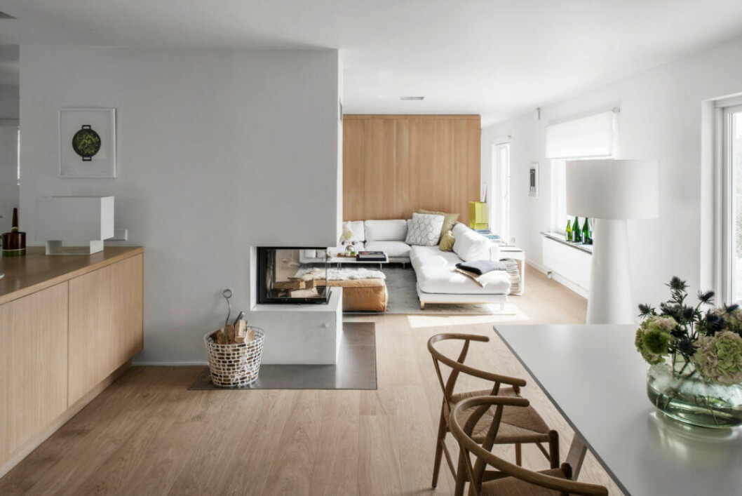 Bord Bermuda, design Thomas Eriksson för Asplund collection, och stolar CH24 av Hans J Wegner för Carl Hansen & Søn. Golvlampa Big shadow, Marcel Wanders för Cappellini. Sidobord West av Jessica Signell Knutsson för Asplund collection. Soffa från Living divani och soffbord Orly, Jasper Morrison för Cappellini. Matta Convex carpet, design Pia Wallén för Asplund collection. Läderpuff, Living divani. Vedkorg Code, Ola Wihlborg för Asplund collection. Det härdade ekgolvet kommer från Bjelin. Köksbänk platsbyggd av Asplund studio. Ovanpå står lampan Seam one, design Mark Holmes för E15. Öppen planlösning hemma hos Asplunds.