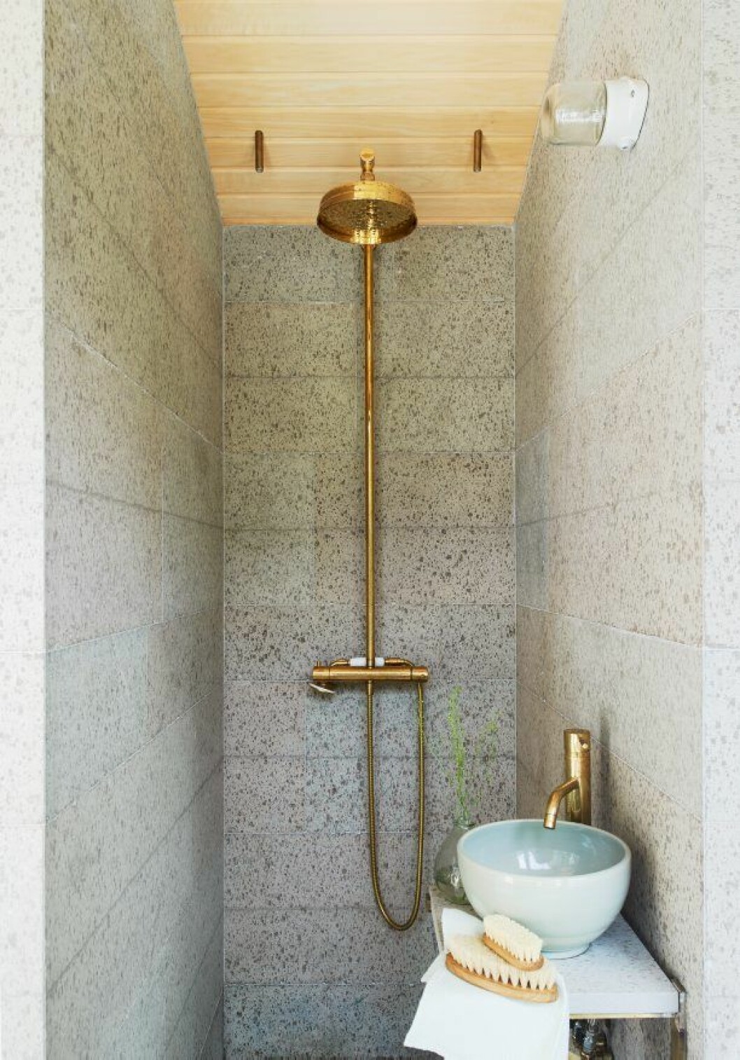 Elegant spaavdelning i grå ölandssten. Dusch och blandare i mässing från Tapwell, belysning Ifö. Borstar från Norrgavel. Orangeri, Jordens Arkitekter