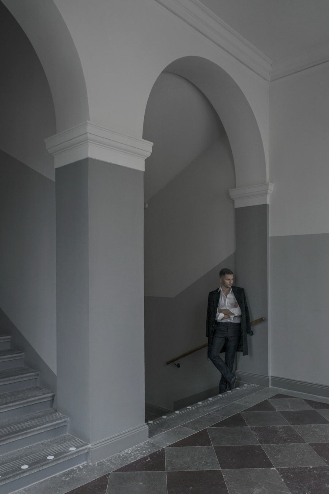 <em>Oscar Properties och Andreas Martin- Löf Arkitekter har förvandlat de gamla byggnaderna i kvarteret Vega som tidigare huserat alumner som Gunnar Asplund – och en viss August Strindberg som kuggade sin kemikurs här 1869.</em> Bild på Alexander Söderqvist i trapphuset på lägenheten i kvarteret Vega.