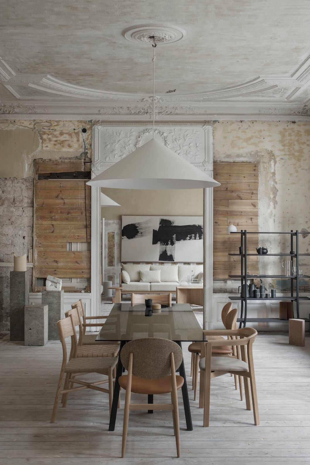 <em>Till höger: Vägg- och takarmatur från Wästberg och matbord och stolar från Ariake, designade av Gabriel Tan, Norm architects och Staffan Holm. Hylla Ariake. Piedestalerna i strukturerad betong av Matti Carlson, och på dem skulpturer av Nick Ross och Fred Layman, Nordlings antik. Den lilla vasen som balanserar längst ut på bokhyllan kommer från Kollekted By. Målningen på den borte väggen av Emma Bernhard, Belenius gallery.</em> Bild på matbord och stolar från Residences utställning a quiet reflection tillsammans med Ariake.