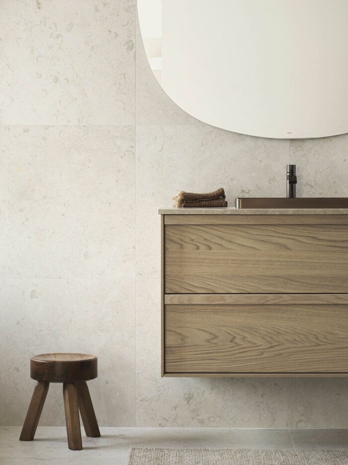 Beige och grått är tidlösa favoriter i badrumsinredningarna. På vägg och golv på bilden syns Norrvange Ivory från Bricmate. Foto: Bricmate beige badrum med detaljer i trä