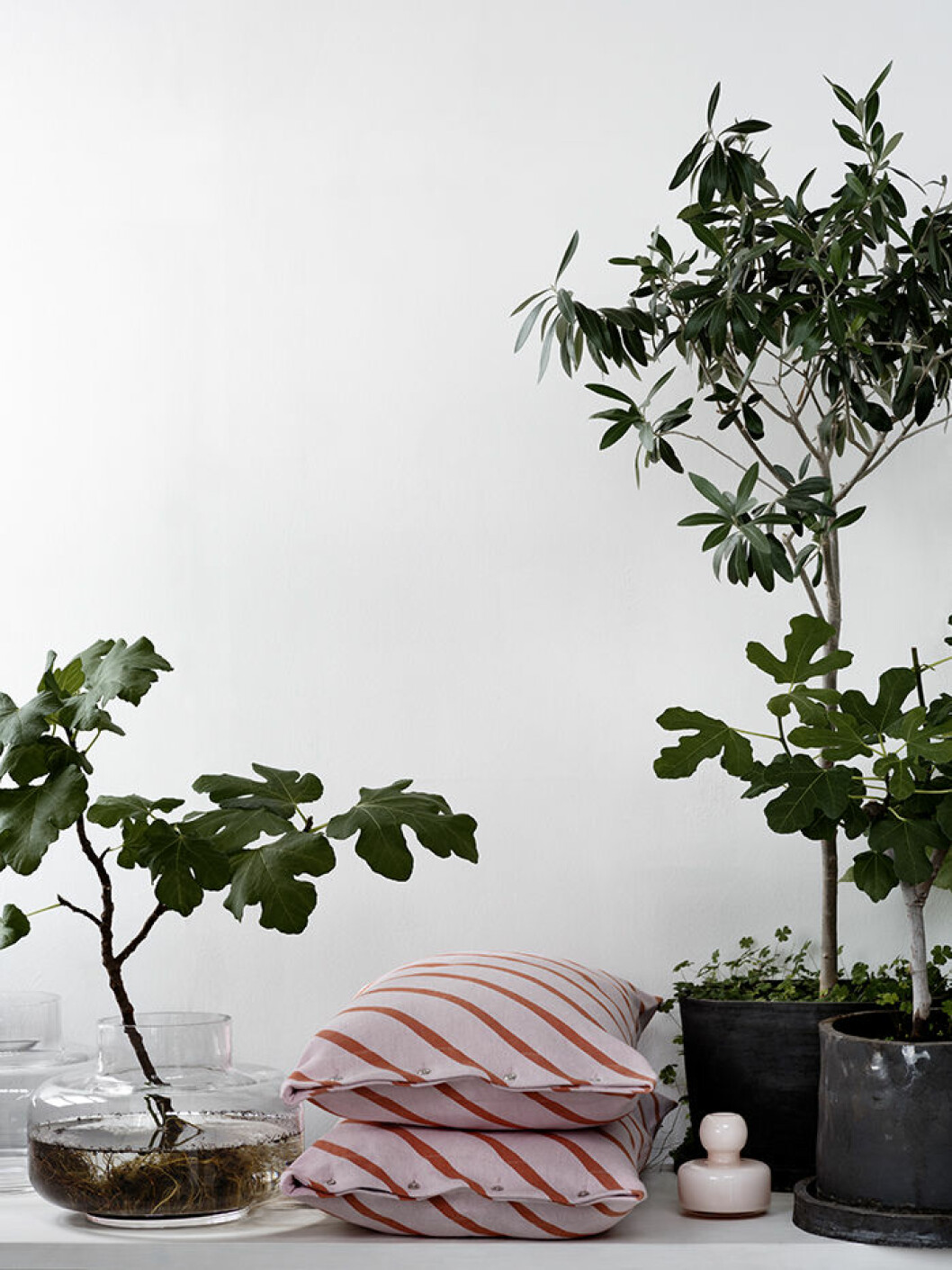 Mönster Mint på kuddfodral i linne. Vasen <em>Urna</em> (t v) med sin vida hals kan sluka en bukett. Rosa vas <em>Flower</em>. Stengodskrukorna är handgjorda i Carinas ateljé i Gustavsberg. Carina Seth Andersson Marimekko Foto Pia Ulin2