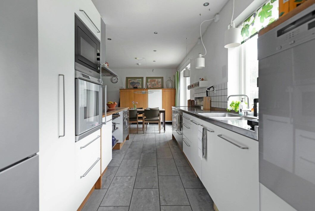 Köket går i vitt och grått, med några få trädetaljer. Kika in i arkitektritade 40-talsvillan.