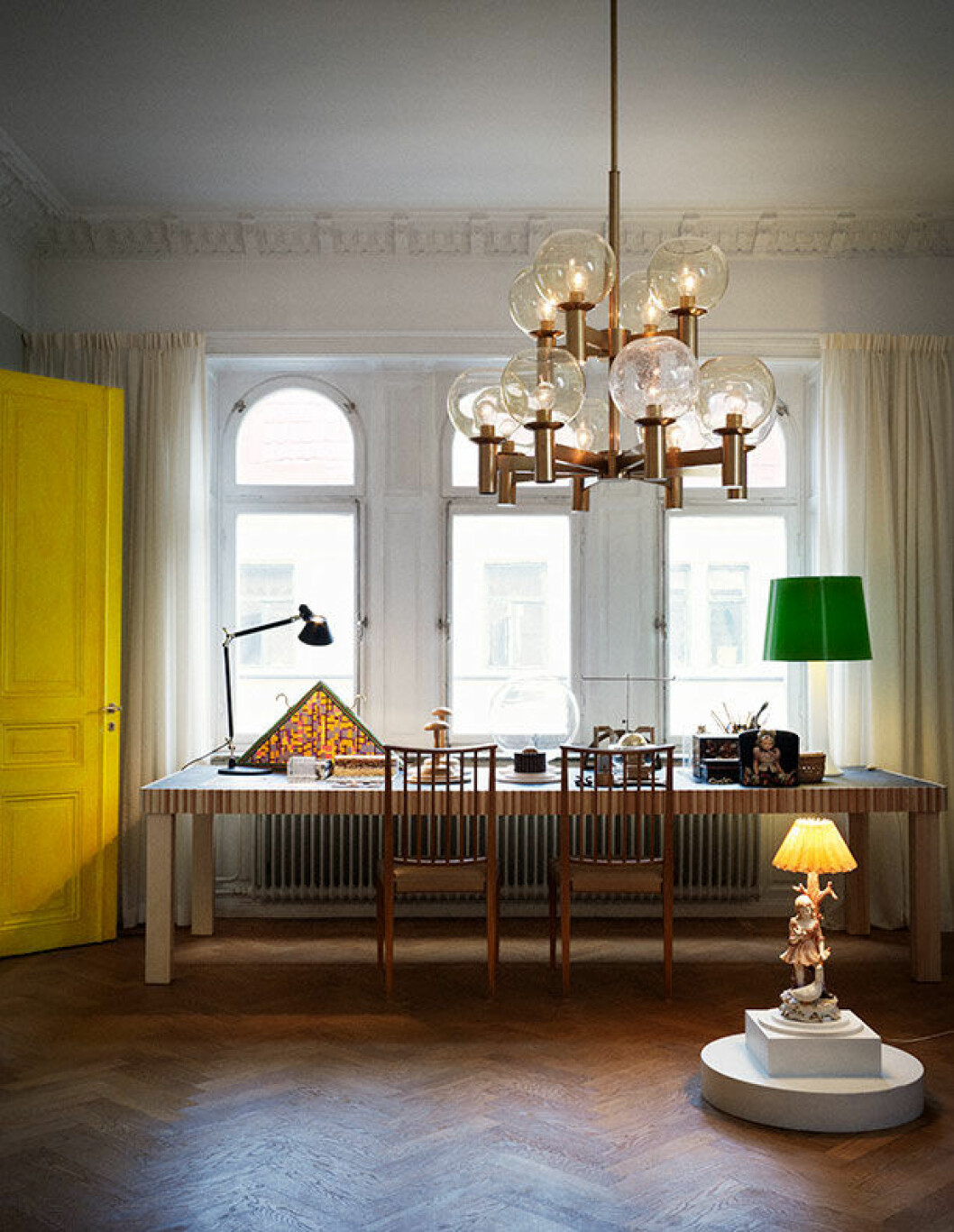 Arbetsbord som även fungerar som matsalsbord är Cillas design. Takkronan inköpt på Gamla lampor. Skrivbordslampa, Artemide. Josef Frank-stolarna kommer från Cillas föräldrahem, där de stod i matsalen. Lampan på golvet, antik. cilla ramnek
