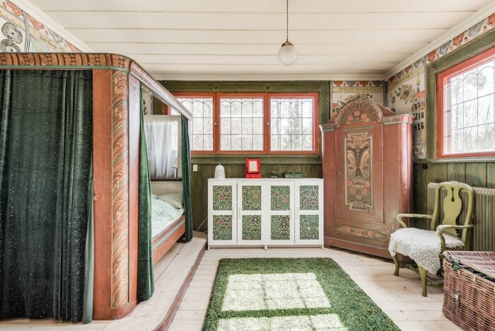Som taget ur en Carl Larsson-målning. Ett av sovrummen på gården är fyllt av vacker allmoge. Gården Norhaga i Falun till salu nationalromantik väggmålningar sovrum
