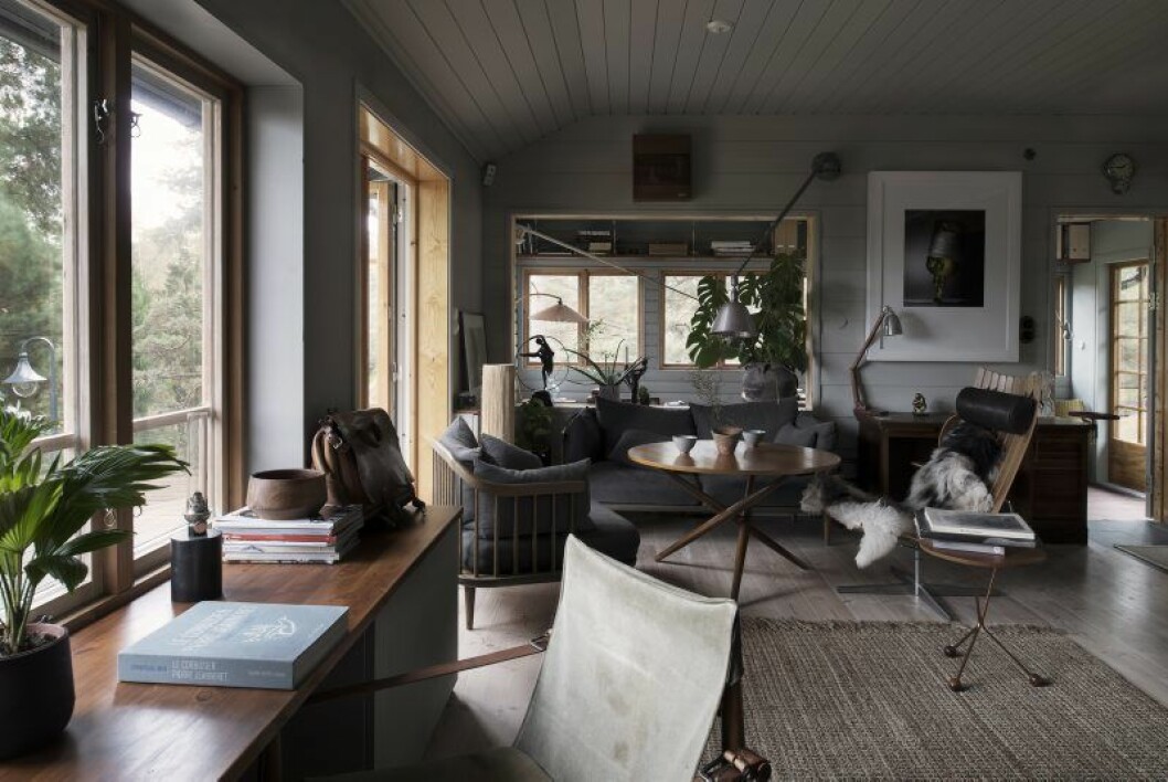 I huset råder en säregen stämning av mogen inredning med grå väggar, antikviteter och mycket träkänsla. Kalle älskar trä. Lampor Triplex, soffa och fåtölj från & tradition, bord Jurg Bally, Bord S-Table, fåtölj Hans Brattrud. Fotografiet på väggen, Pelle Bergström.