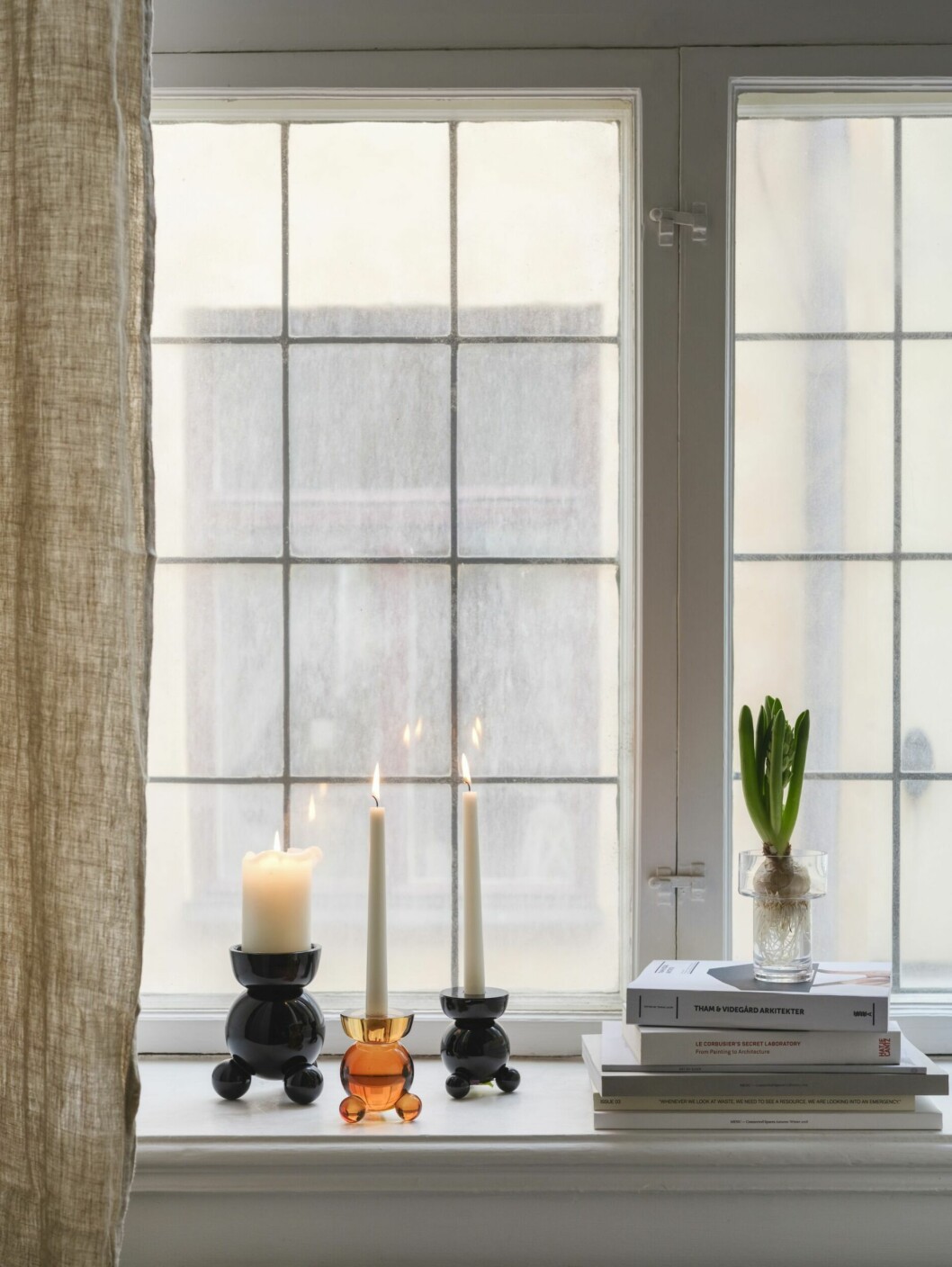 Bärnstensfärgat glas, tända ljus och en doftande hyacint – en trio som gör fönsterbrädet eller sidobordet julfint! fönsterbräde med juldekorationer