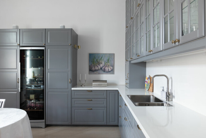 Det moderna köket har en klassisk touch med grå träluckor.