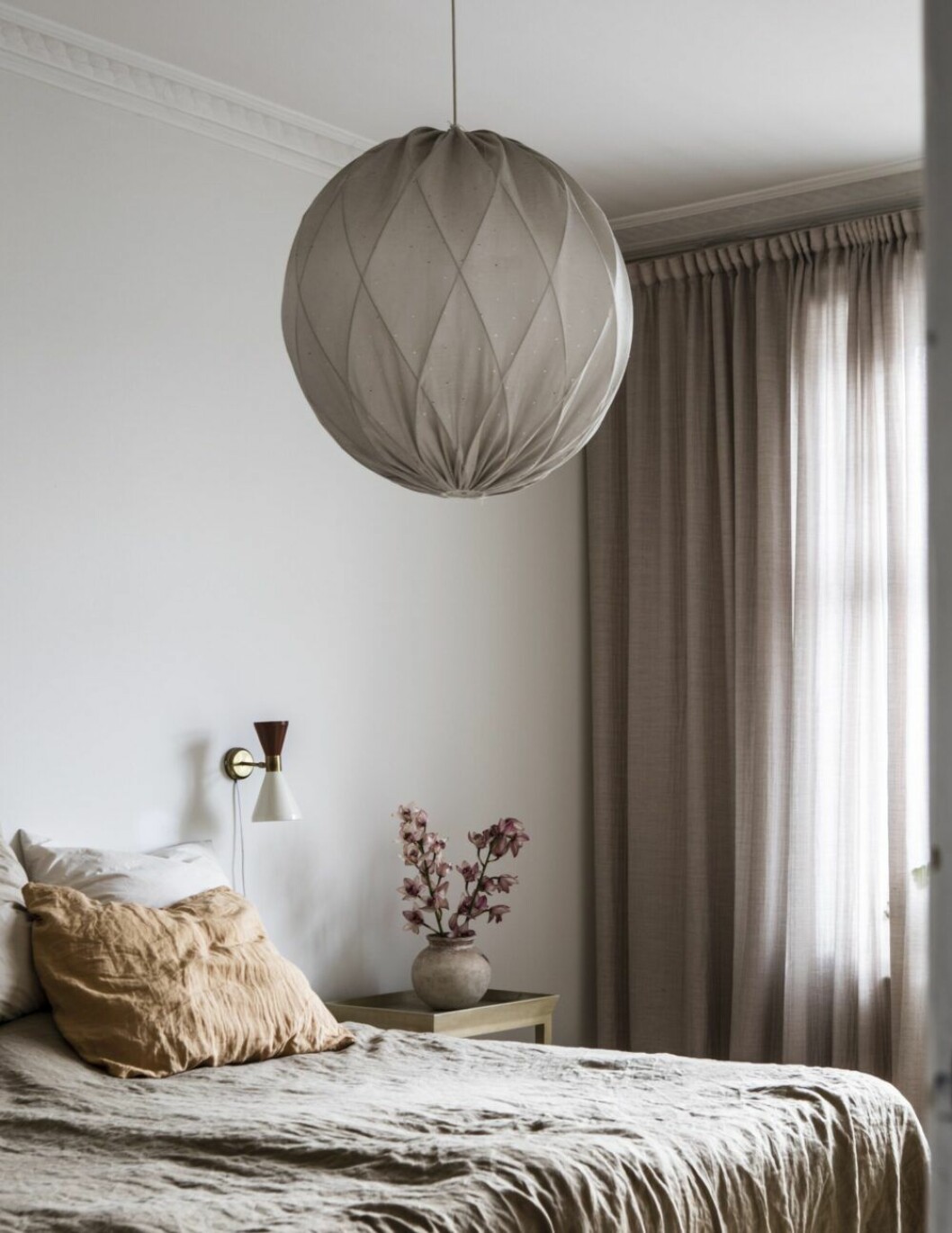 Sovrum med gardiner från Astrid i Stockholm. Taklampan är en Pia-lampa, ritad av arkitekten Tore Ahlsén 1975 för Gärsnäs. Vas köpt på den årliga antikmarknaden i franska Pézenas.