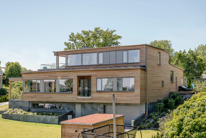 Stora fönsterpartier blickar mot vattnet i den moderna villan. Villa till salu Strandvägen Djursholm