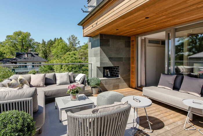 På en av terrasserna finns en murad öppen spis. Uteplats vid villa till salu Strandvägen Djursholm