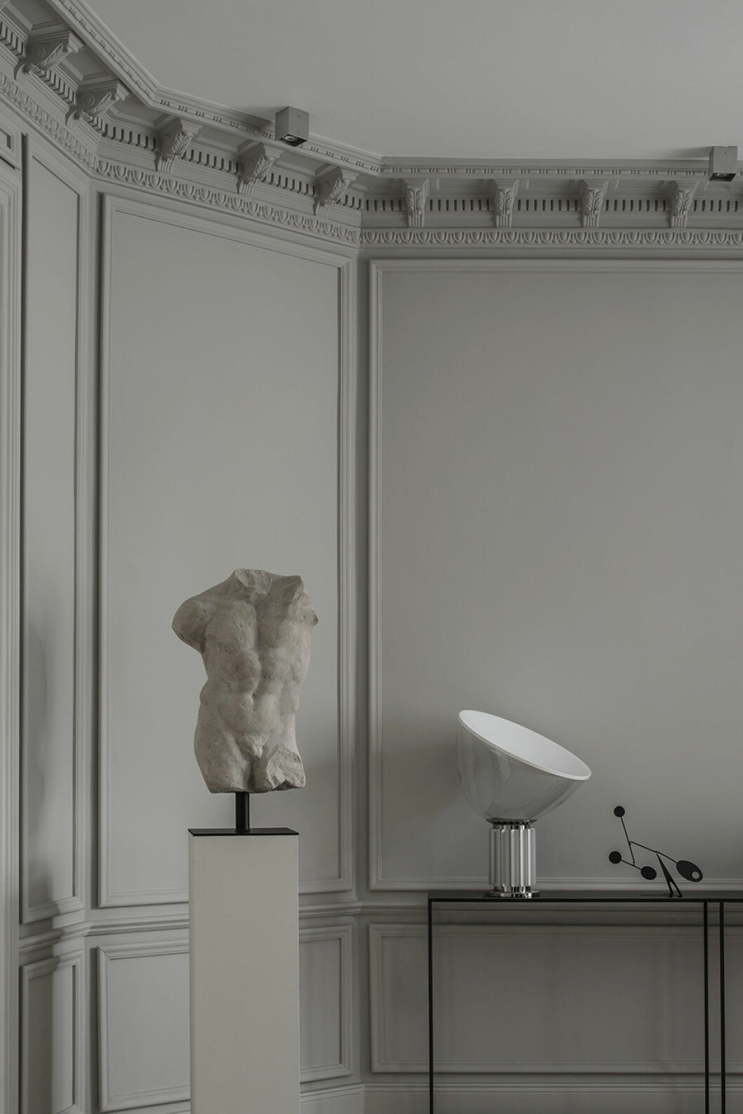 Med bakgrund som konsthistoriker har Emma samlat på sig en hel del verk på vägen. Piedestalen som den nakna torson står på har Emma ritat och lått tillverka själv. Bordslampan Taccia är designad av Achille Castiglioni för Flos. Mobilen blev över från en fotografering och är inköpt från Fondation Maeght. emma b staty