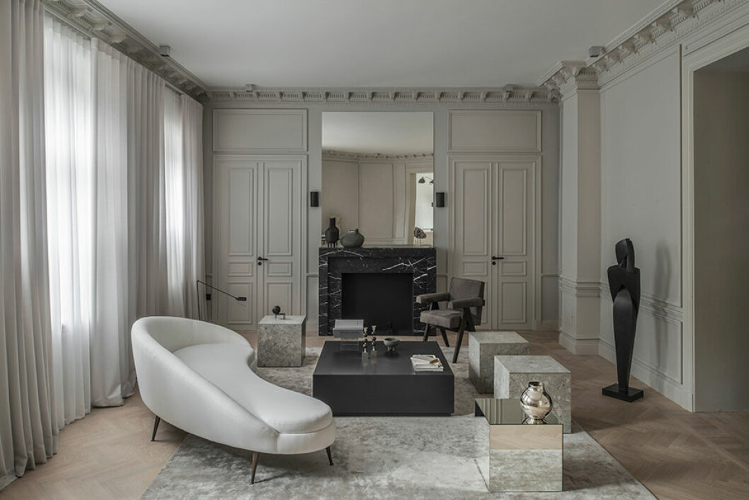 Dörrarna är trompe l’oeil och bidrar med dynamik i rummet. Den öppna spisen är ritad av Emma enligt fransk modell. Soffan Porto är från Layered, och det mattlackade soffbordet har Emma låtit tillverka själv. Sidobordet i sten från Apartment Stories, och sidobordet i glas är från Perspective Studio. Karmstolen framför spisen är designad av Pierre Jeanneret. Den stora svarta skulpturen Blick av konstnären Britt-Ingrid Persson i svartpatinerad brons. Det är konstrådgivaren Moderna Samlare som curerar Emmas konst, de hyr ut konst till både privatpersoner och företag. emma Blomquist överblick