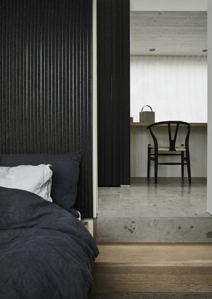 Sovrummen har fast möblemang för att spara utrymme. Vid den lilla arbetsstationen står stolen CH24, design Hans J. Wegner för Carl Hansen & søn. Sovrum i sommarhus på Gotland