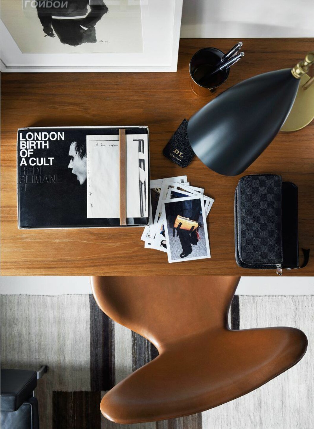 Arbetshörna i bokhyllan. Fodral från Louis Vuitton och en av de många fotoböckerna ur Daniels samling, denna av fotografen och<br>modedesignern Hedi Slimane.