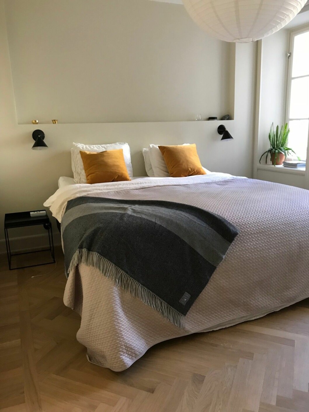 Beige färgton med färgklickar i form av kuddar och grönska i sovrummet. Sovrum i beige färgton med färgglada kuddar och växter.