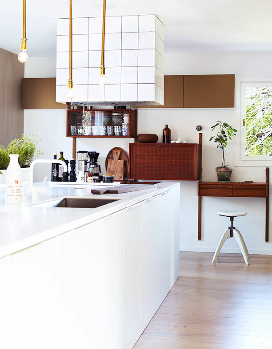 <em>Köksskåpen av Siematic, köksbänk i corian, teakskåp köpt på Lauritz, vit pall, Myrorna, fläkt ritad av Jenny och klädd med vitt standardkakel, skärbräda från Lotta Agaton shop.</em> flaktkapa kakel