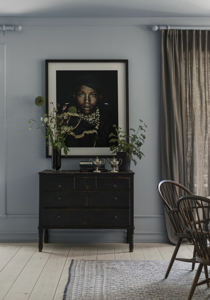 Ovanför byrån, köpt i L’Isle-sur-la-Sorgue i södra Frankrike, hänger fotografen Jimmy Nelsons porträtt XXVIII Vodaabe, Tchad. De äldre norska stolarna är ärvda. Matta från Dusty deco. Gardiner från Lotta och Lisbeth. Fotografi av Jimmy Nelsons porträtt XXVIII Vodaabe, Tchad