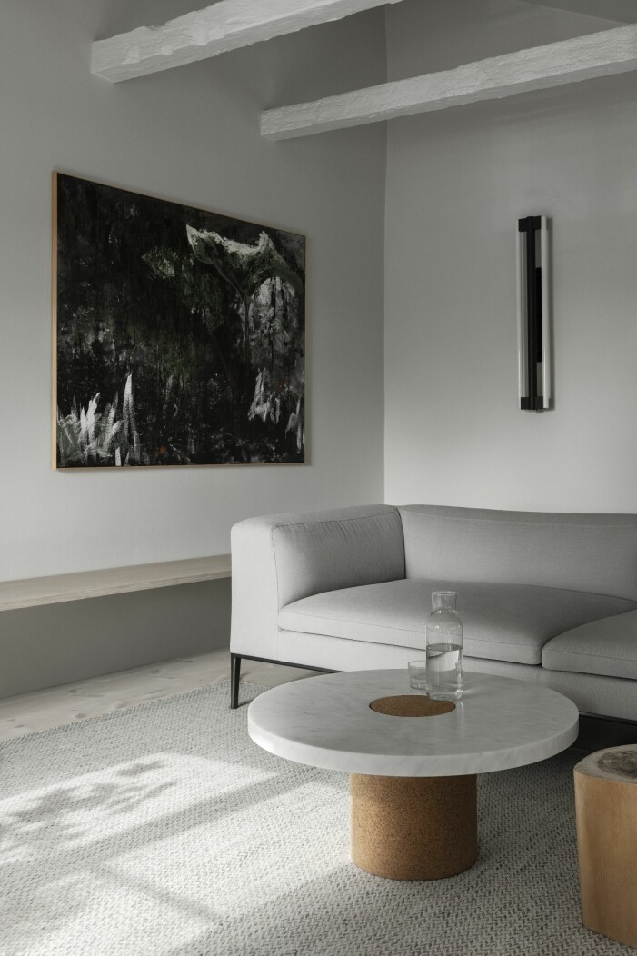 I sällskapsrummet står en specialversion av Framas Sintra-bord med ben i kork och skiva i marmor. På vägen syns Framas Eiffel-lampa, en tavla av Charlotte Trampedach och soffan Sofia från B&B Italia. vardagsrum