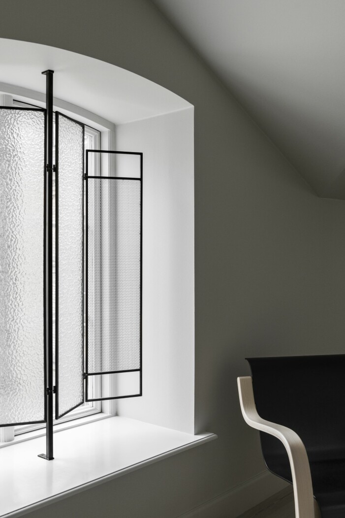 Rundningen i fönstret krävde en speciallösning och då uppkom idén att designa skärmar i glas och mässing. Denna i glas passar perfekt där ändamålet är insynsskydd utan att stänga ute ljuset. insynsskydd