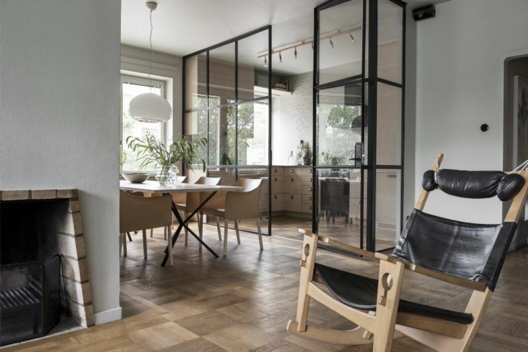 Vardagsrummet och matsalen binds samman av sin ekparkett och är centrerade kring en öppen spis. Gungstolen av Hans J Wegner är en prototyp. Vardagsrummet och matsalen binds samman av sin ekparkett och är centrerade kring en öppen spis. Gungstolen av Hans J Wegner är en prototyp.