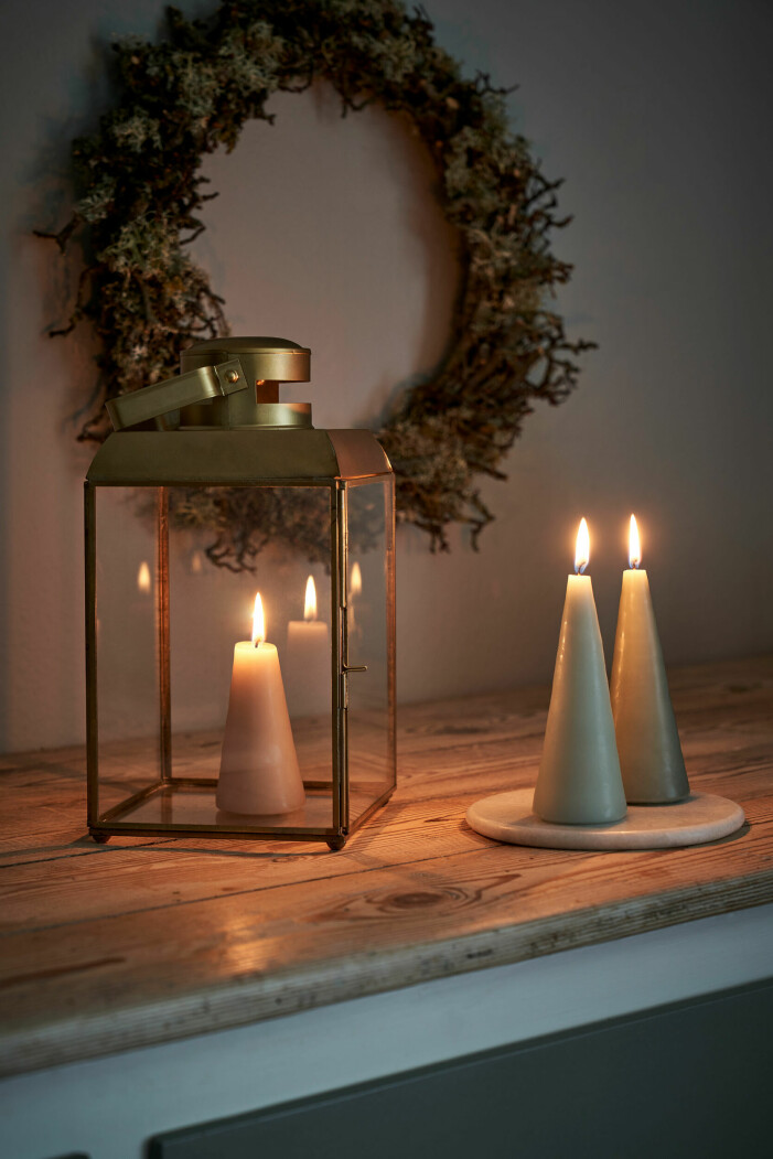 Skapa ett juligt stilleben med stämningsfulla ljuskällor och en grönskande julkrans på väggen – eller bordet. Foto: Søstrene Grene. Gör din egen julkrans, inredningstips