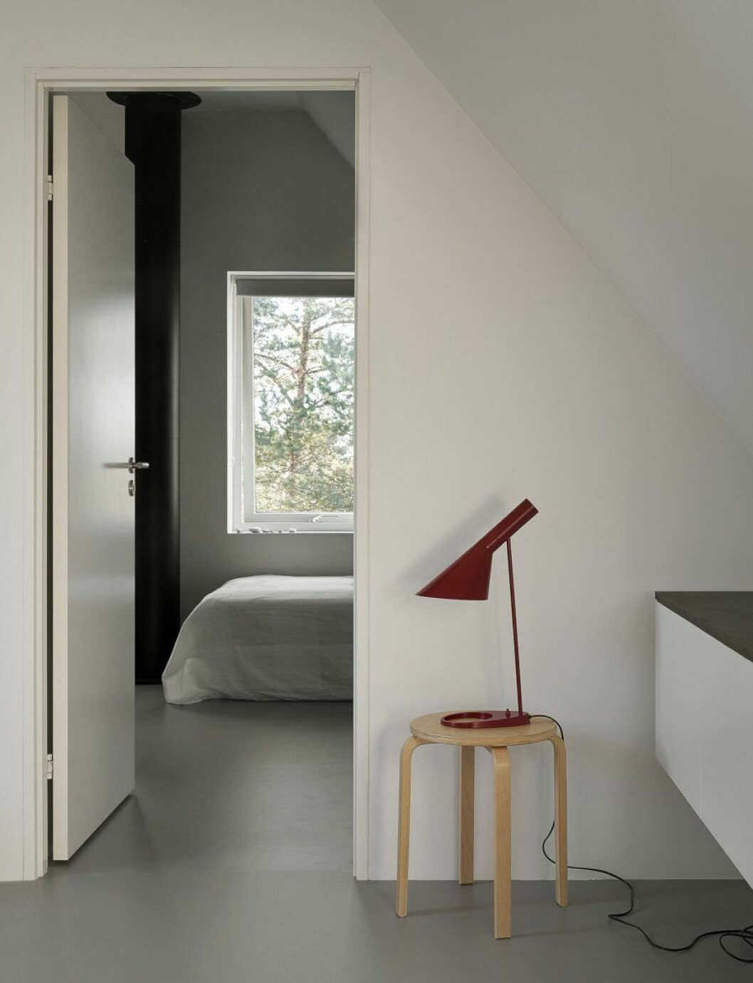 Innanför övervåningens tv-rum ligger ett större sovrum för sönerna Otto, Ville och Love. På pallen står Arne Jacobsens AJ-lampa i bordsmodell.