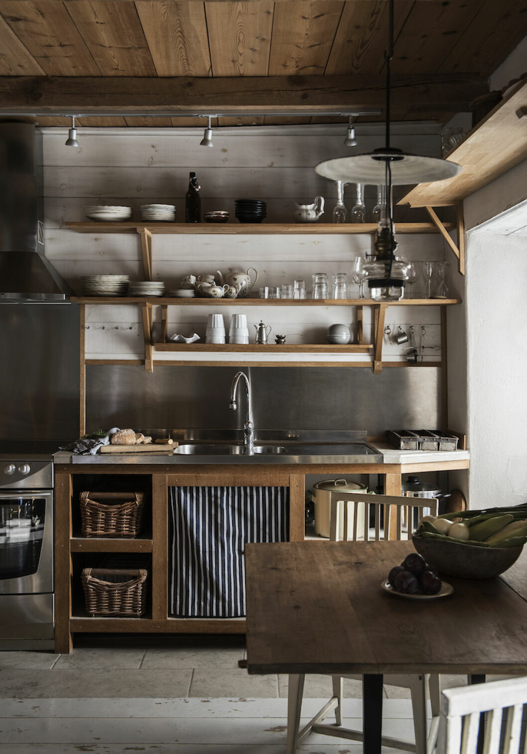 Köket är byggt på plats av snickaren som renoverade huset. Enkla funktionella lösningar med öppna skåp och rottinglådor. Köket hemma hos Johan Lindskog och Joanna Sundström på Gotland.