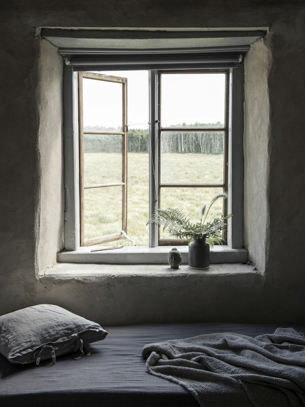 Fri utsikt från övre plan mot åkrar och skog. Sängkläder, Society. Kudde, NK Classic home. Stillsamt sovrum med sängkläder från Society hemma hos Joanna Sundström och Johan Lindskog.