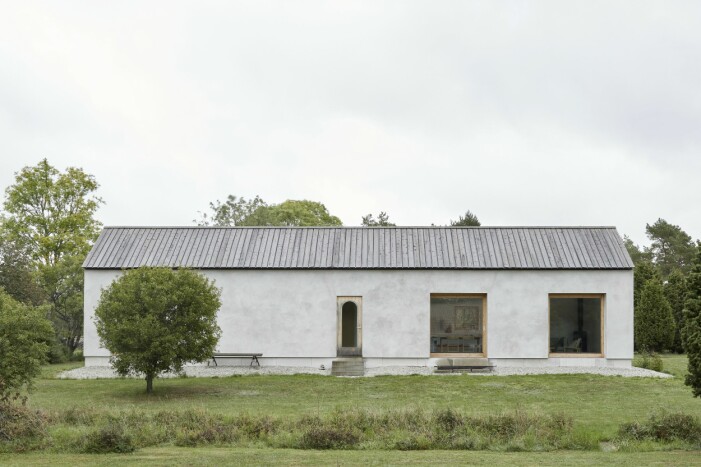 Ett gotländskt stenhus av trä, glas och betong, 103 kvadratmeter med en modern twist. Bänken framför huset är gjord av färdiga bockar från ett gotländskt snickeri, och hopskruvad av Marjo och Mats. Gotländskt stenhus.